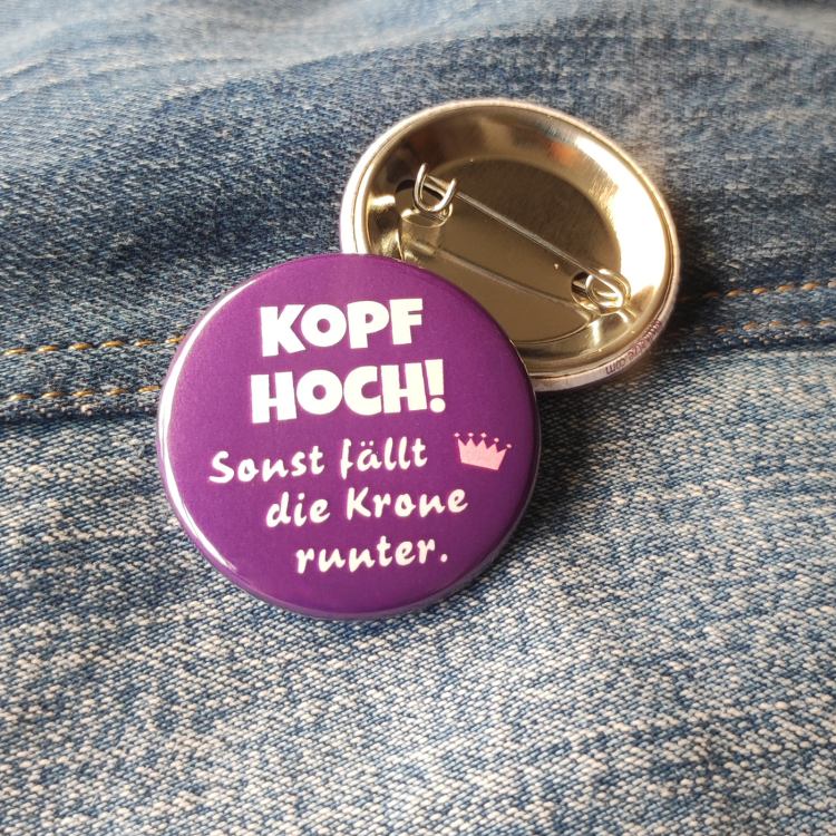 Ansteckbutton Kopf hoch, sonst fällt die Krone runter auf Jeans mit Rückseite